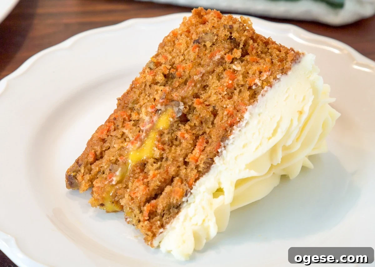 a slice of orange curd filled carrot cake on a white plate