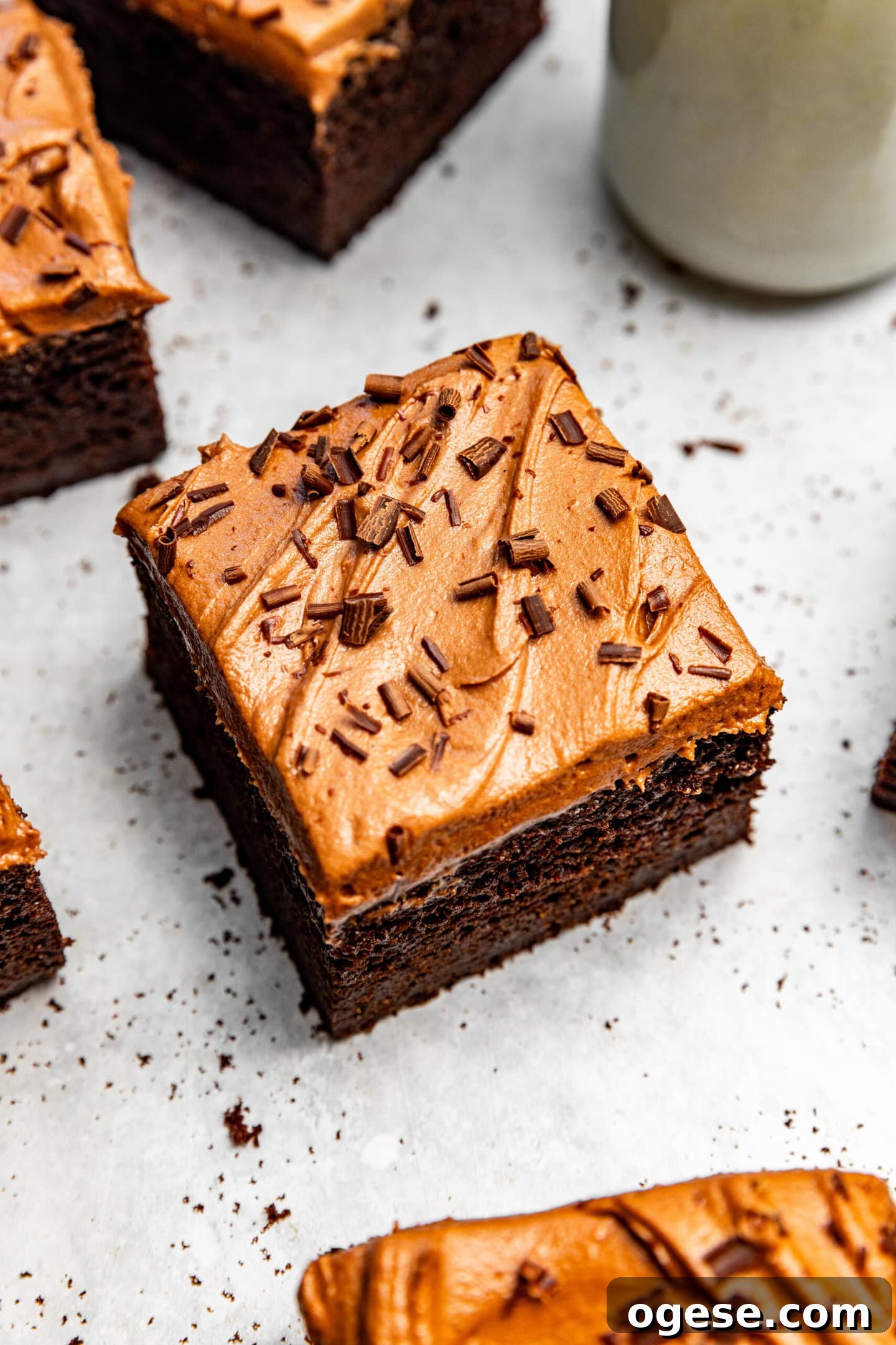 Chocolate fudge buttercream spread on top of a piece of chocolate cake.