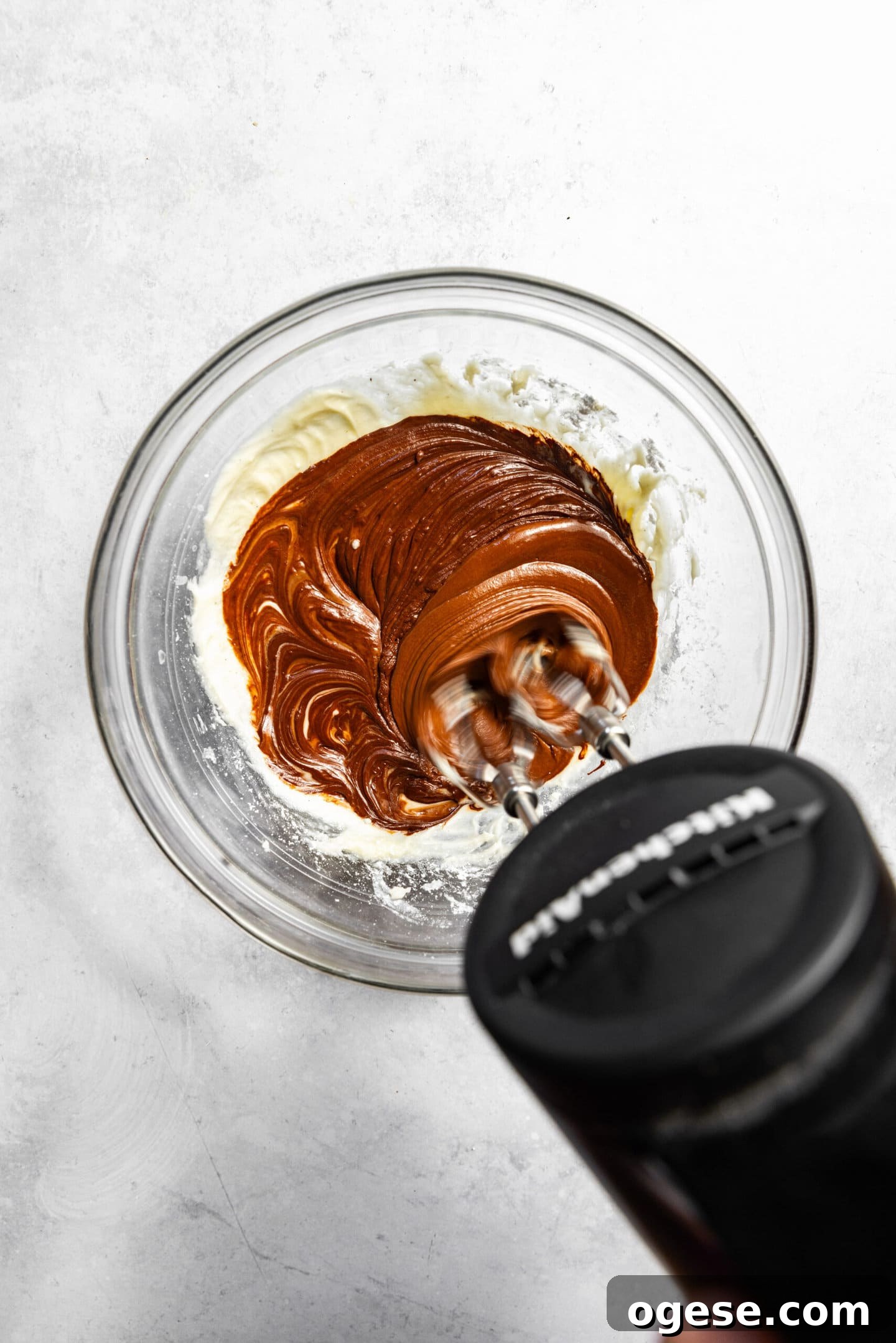 Melted chocolate being beaten into the butter and sugar mixture.