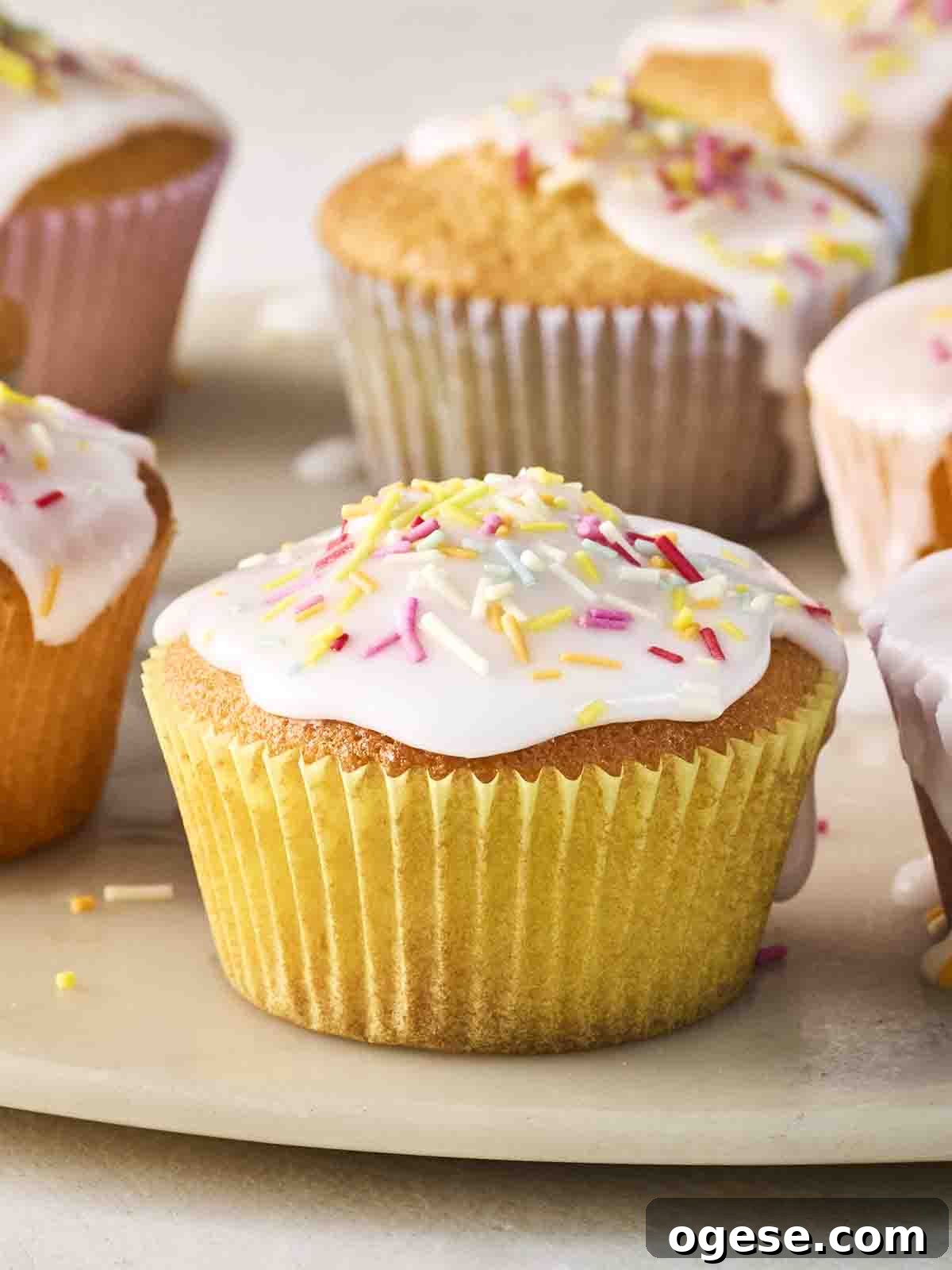 A close up of a decorated fairy cake, with others in the background.