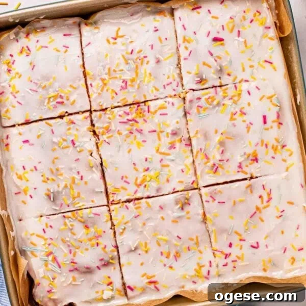 A square School Cake sponge with icing and sprinkles over the top, cut into squares.