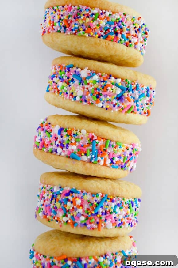 A close-up shot of a stack of ice cream cookie sandwiches rolled in rainbow sprinkles