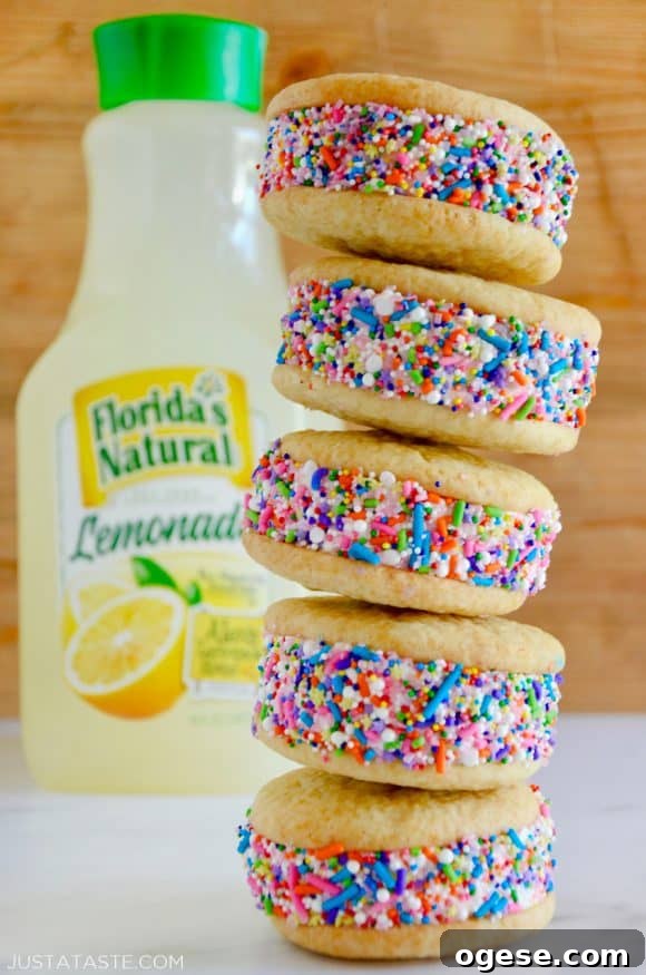 A stack of lemon ice cream sandwiches coated in sprinkles with a bottle of lemonade behind them
