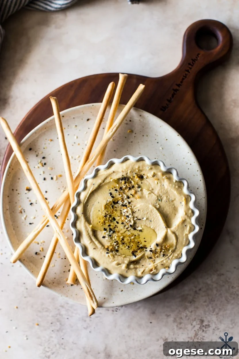 Ultimate Guide to Hummus: Recipes, Tips, and Serving Ideas 2 Overhead photo of a small dish of hummus on a plate with breadsticks