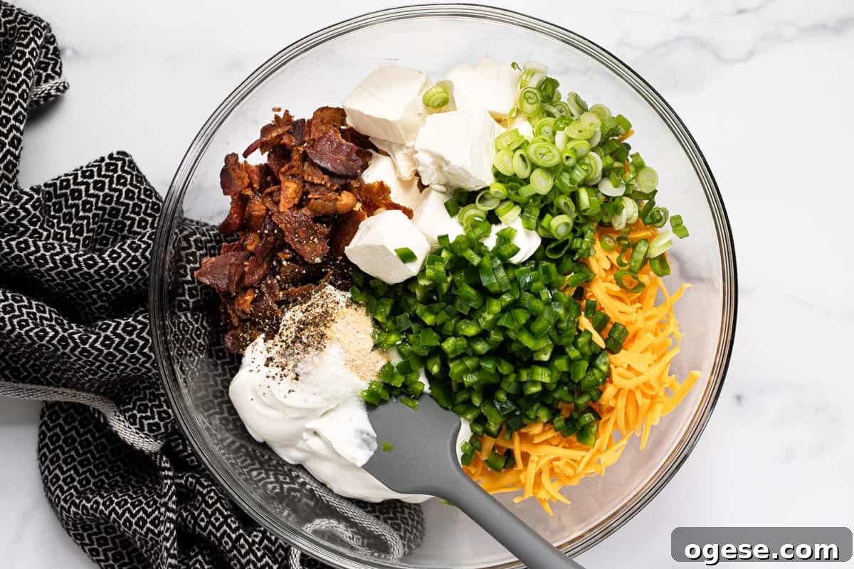 Large glass bowl filled with ingredients to make jalapeno popper dip