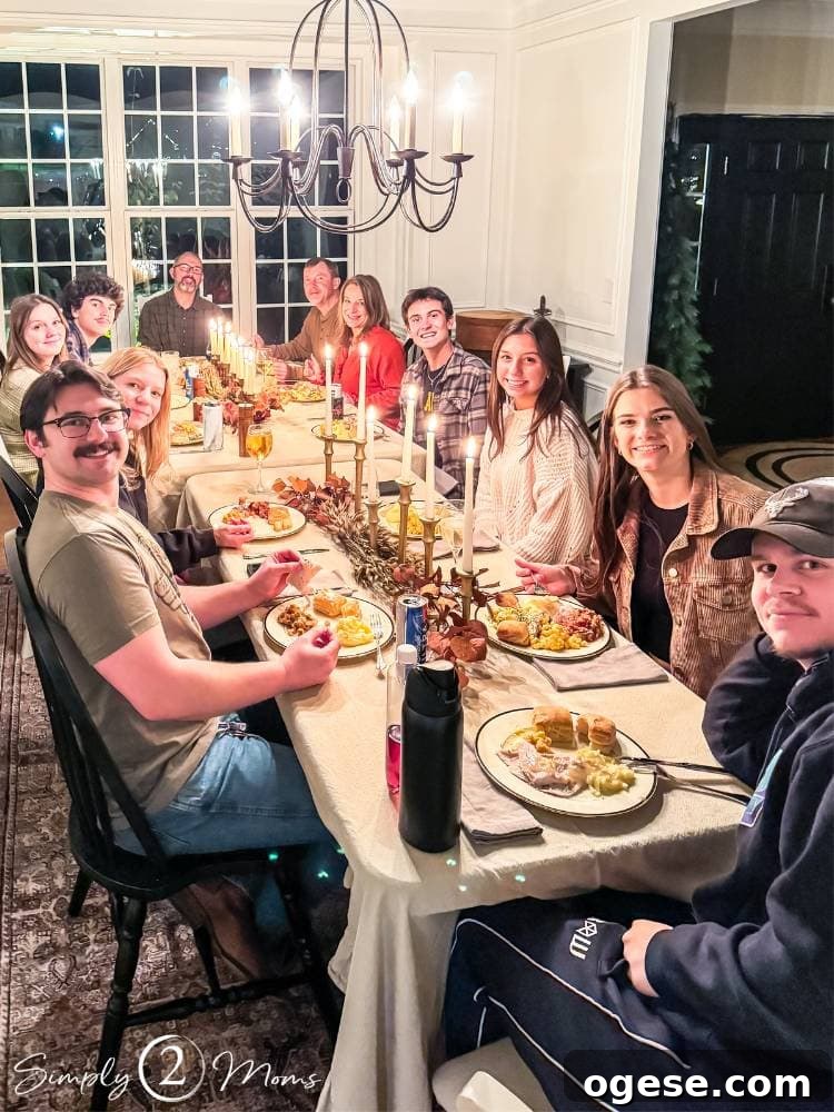 Two families with older kids around the table for Thanksgiving dinner.