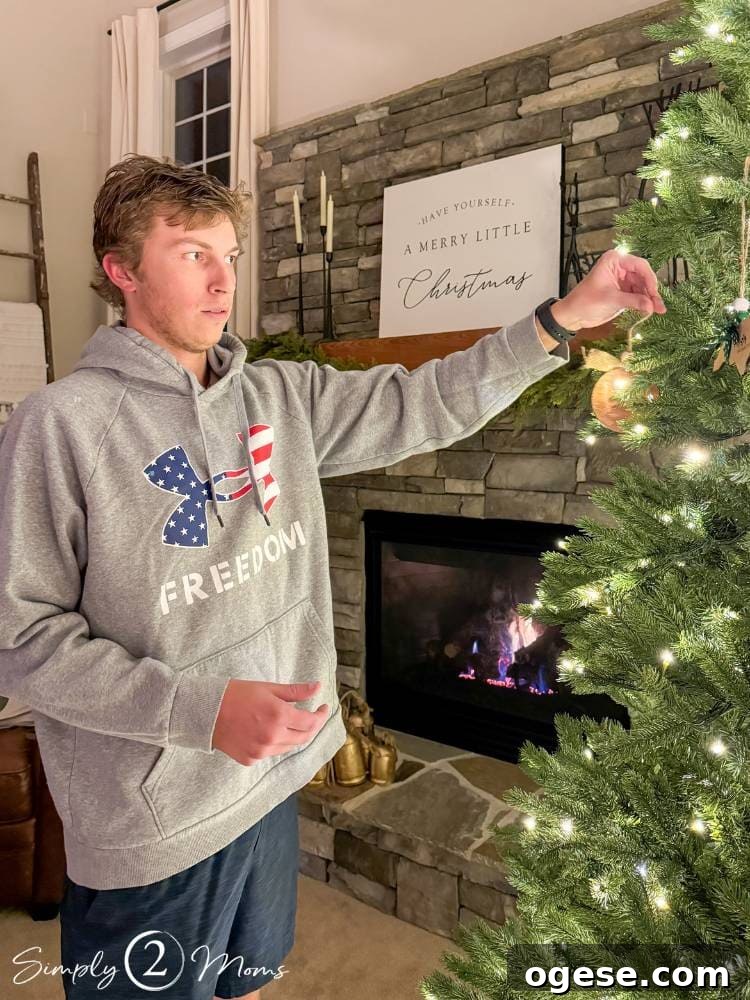 bloggers son hanging ornament on Christmas tree