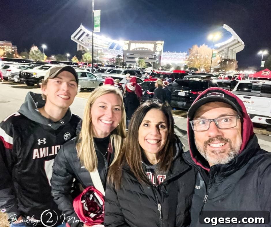 four people standing together at night outside of football stadium