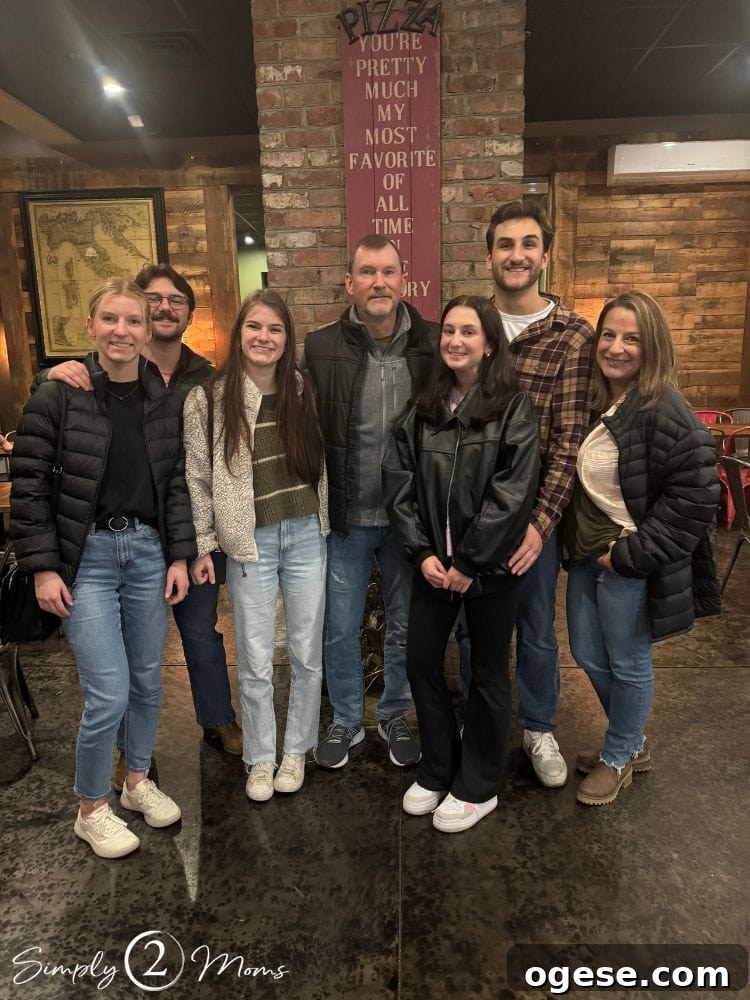 Family of five plus two significant others standing together in a restaurant.