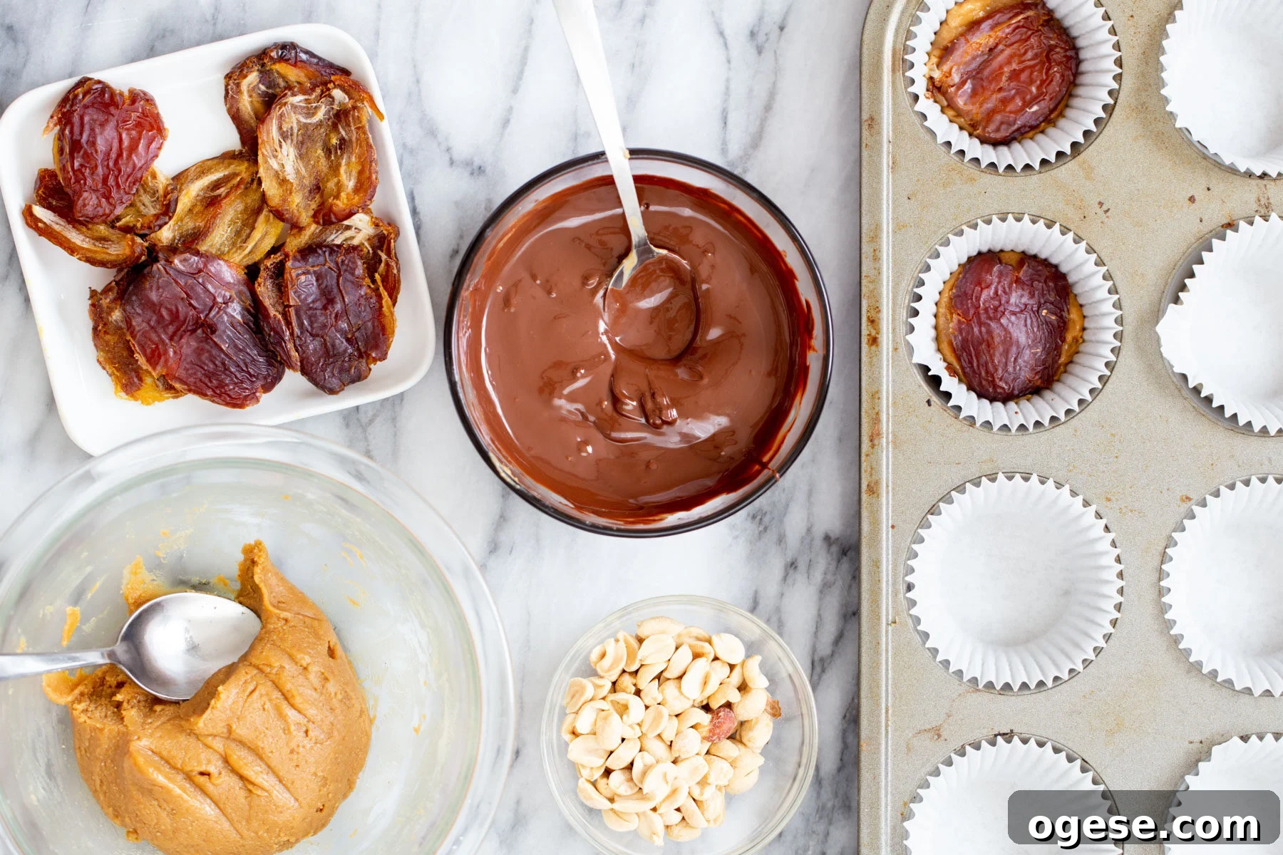 Vegan Snickers-Style Peanut Butter Cups Recipe 9 halved pitted dates being added to chocolate peanut butter cups