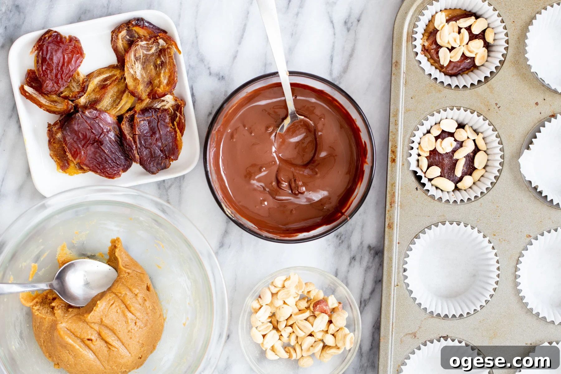 Vegan Snickers-Style Peanut Butter Cups Recipe 10 peanuts being added to peanut nougat filled chocolate cups to make vegan snickers cups