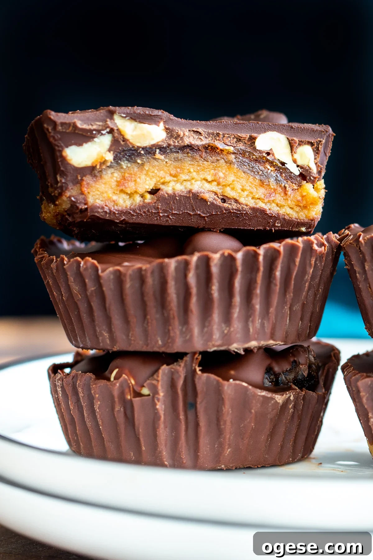 Vegan Snickers-Style Peanut Butter Cups Recipe 3 a stack of vegan snickers cups with dates on a white plate