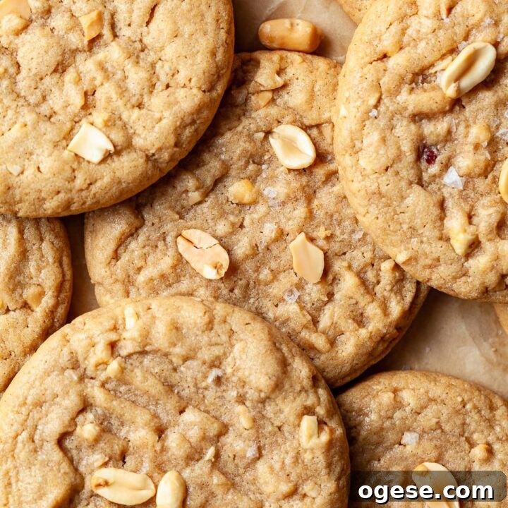 closeup of gluten free peanut butter cookies on a brown paper topped with peanuts and salt