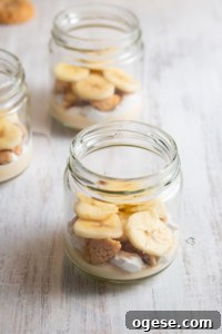 Bananas layered into a jar with cream and nilla wafers.