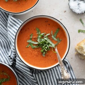 Roasted Red Pepper and Tomato Soup Recipe for Cozy Weeknights 13 Tomato and Roasted Red Pepper Soup garnished with fresh basil.