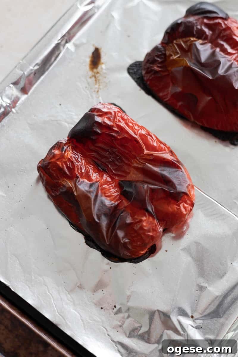 Roasted Red Pepper and Tomato Soup Recipe for Cozy Weeknights 4 Roasted red peppers on a baking sheet.