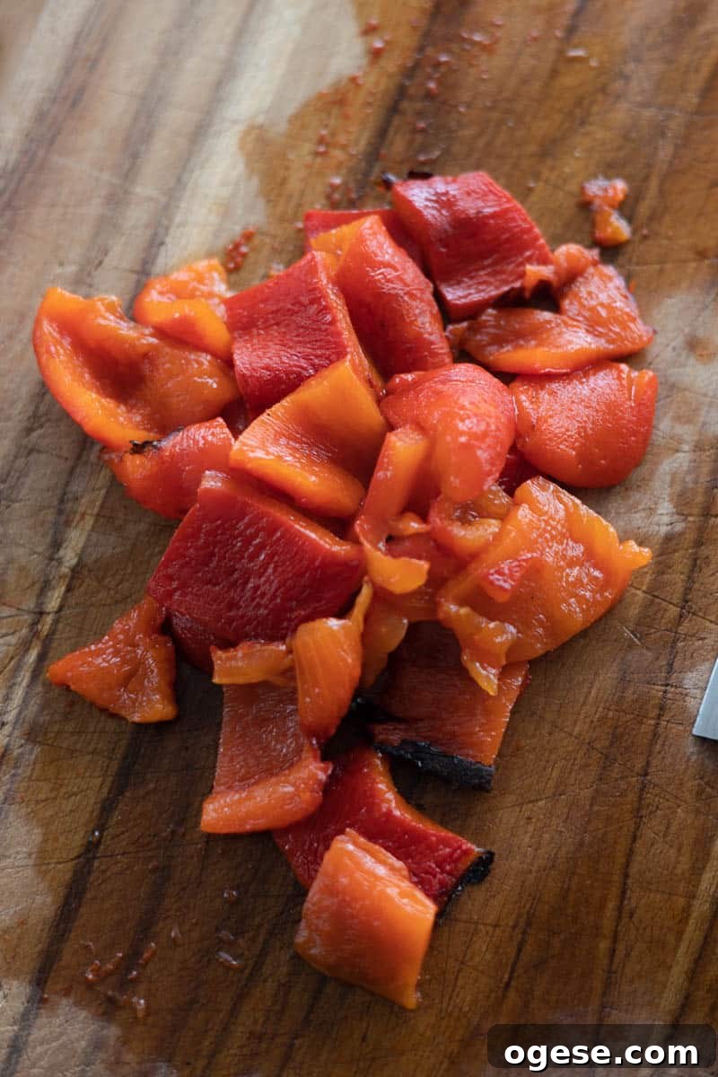 Roasted Red Pepper and Tomato Soup Recipe for Cozy Weeknights 5 Roasted red peppers cut on a wooden cutting board.