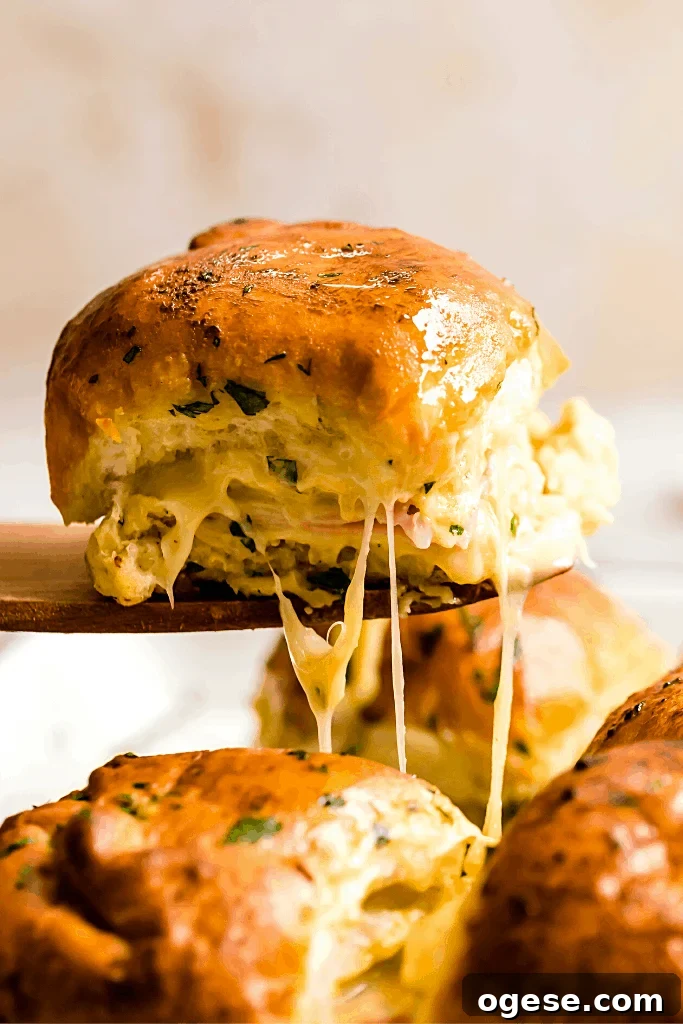 Savory Ham and Swiss Sliders with Honey-Dijon Glaze 2 A Hot Ham and Cheese Slider on a Wooden Serving Spatula