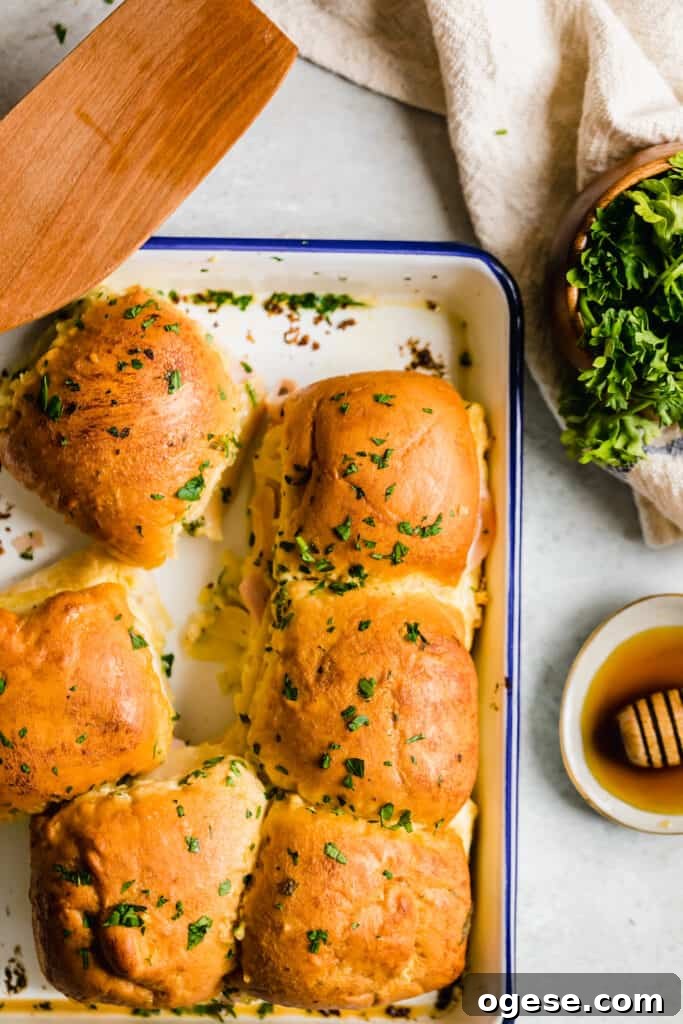 Savory Ham and Swiss Sliders with Honey-Dijon Glaze 8 Six Hot Ham and Cheese Sliders Beside a Bowl of Parsley