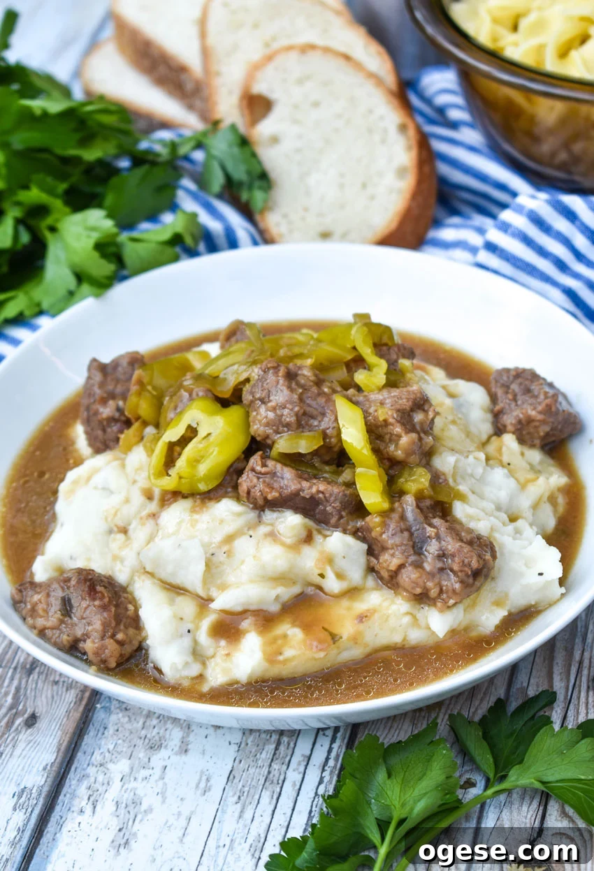 mississippi pot roast served over mashed potatoes in a white bowl