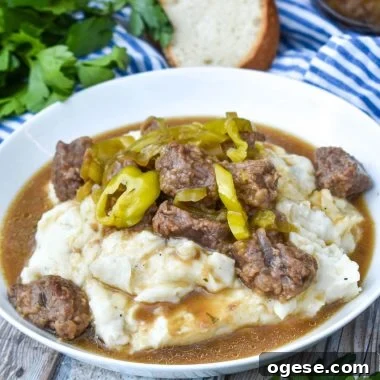 mississippi pot roast served over mashed potatoes in a white bowl
