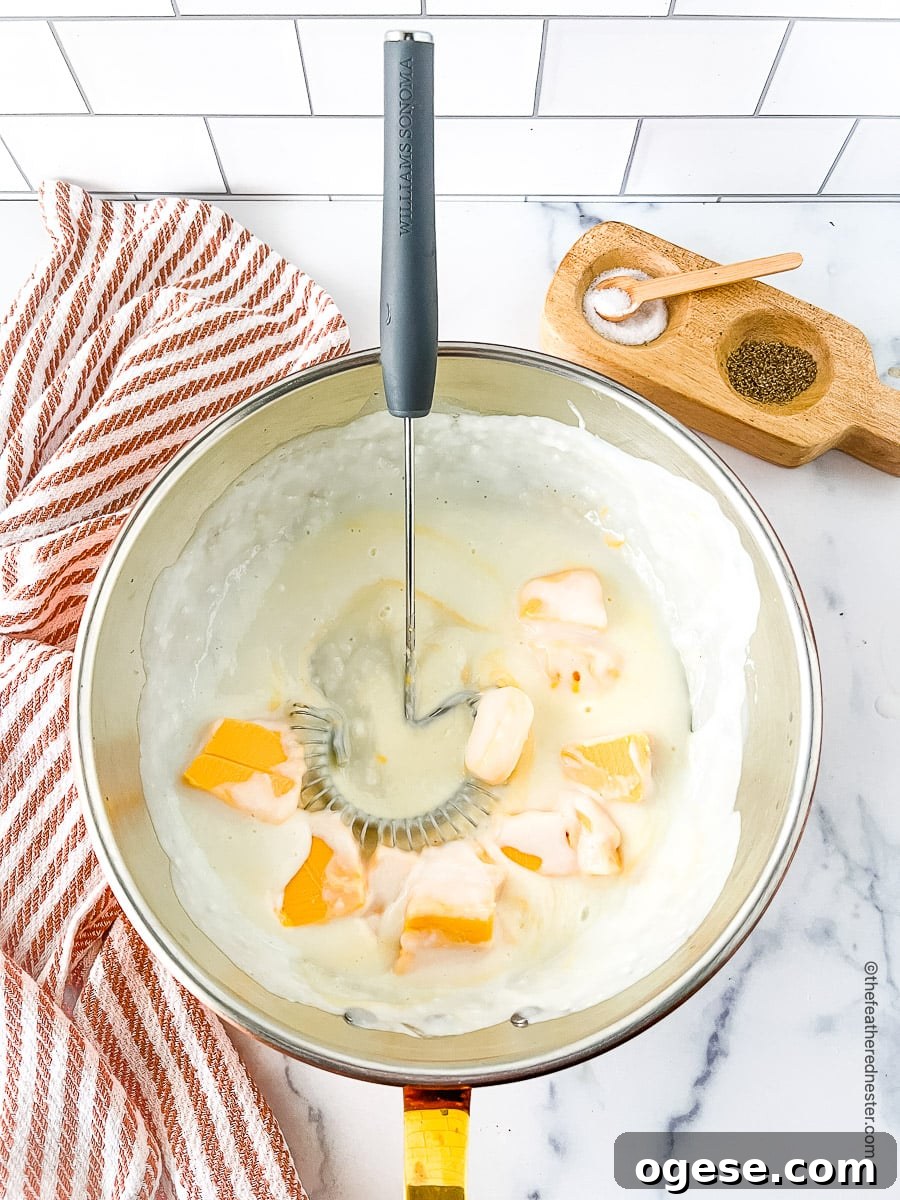 Mixing the cheese sauce ingredients in a large bowl using a whisk.