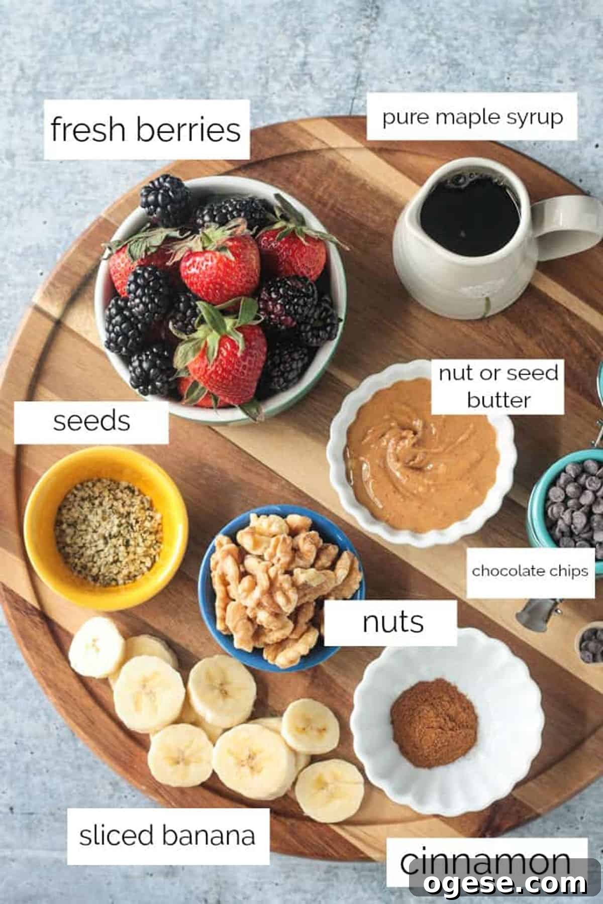 Creamy Oatmeal Recipes for Smooth, Nutritious Breakfasts 7 Topping ingredients arrayed in individual bowls on a wooden serving tray.