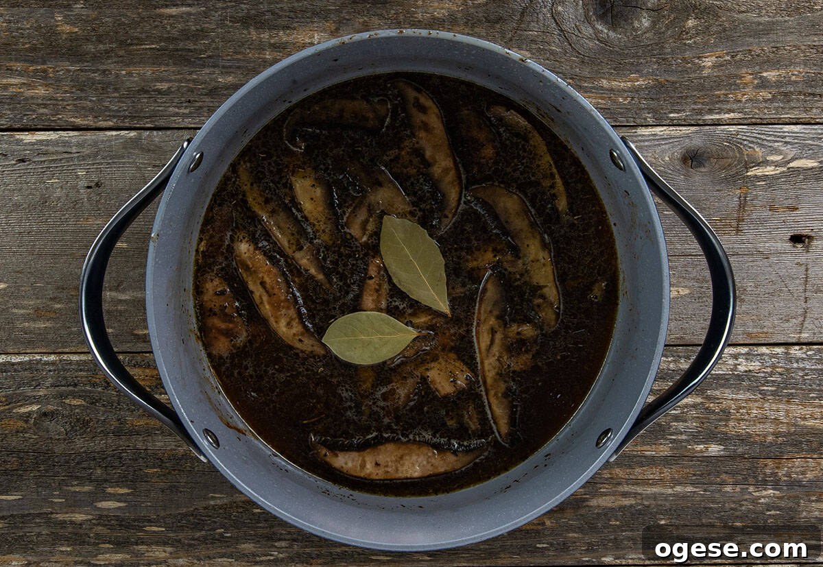 Beef broth and bay leaves added to pot.