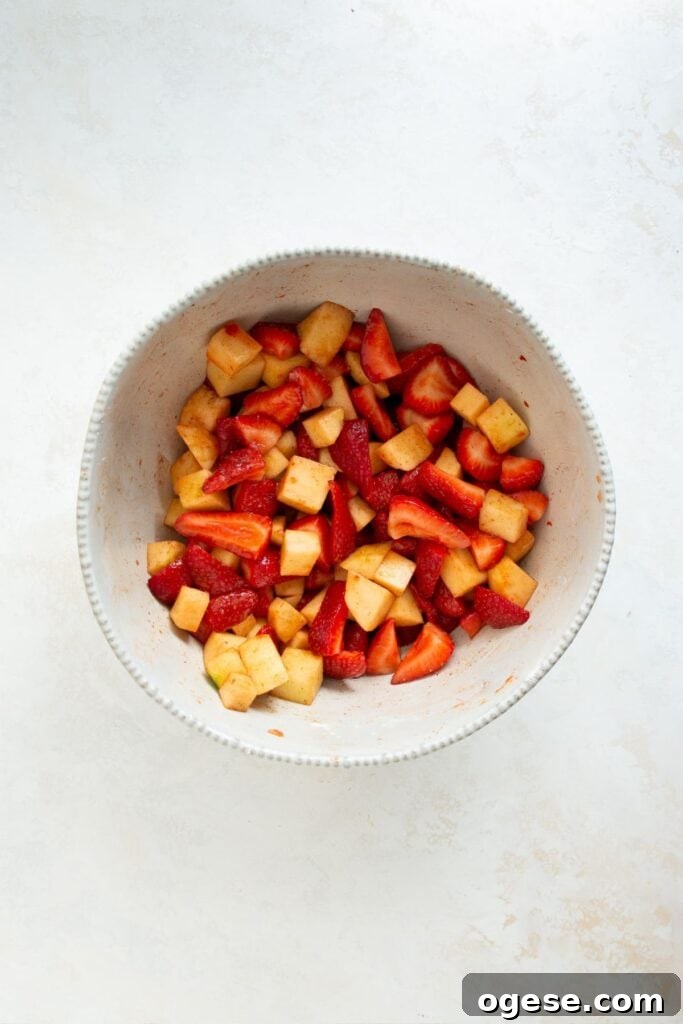 coating cut up strawberries and apple in coconut sugar and cinnamon
