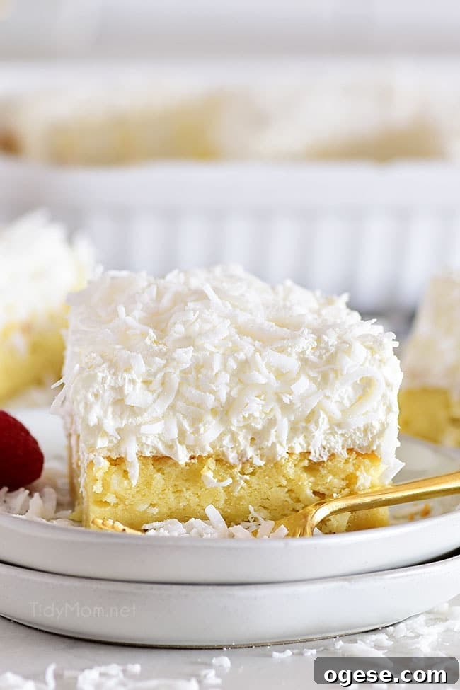 Moist Coconut Cake Recipe with Video Tutorial 2 Slice of coconut sheet cake on a white plate
