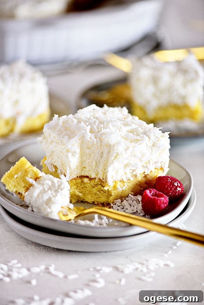 Moist Coconut Cake Recipe with Video Tutorial 6 a bite of cake on a fork next to a slice of cake