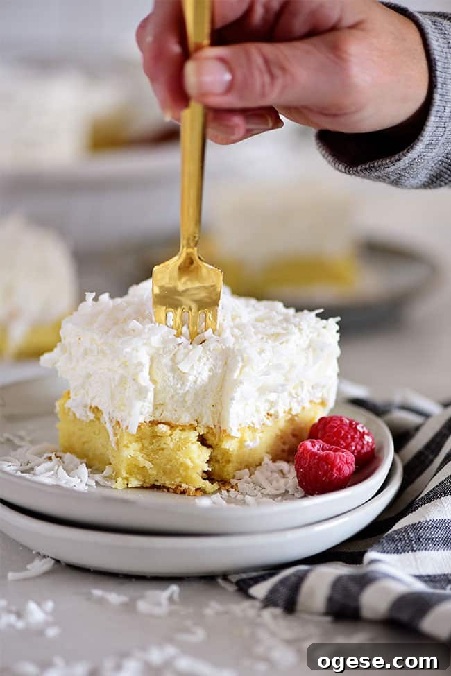 Moist Coconut Cake Recipe with Video Tutorial 8 coconut cake with a gold fork poking into it