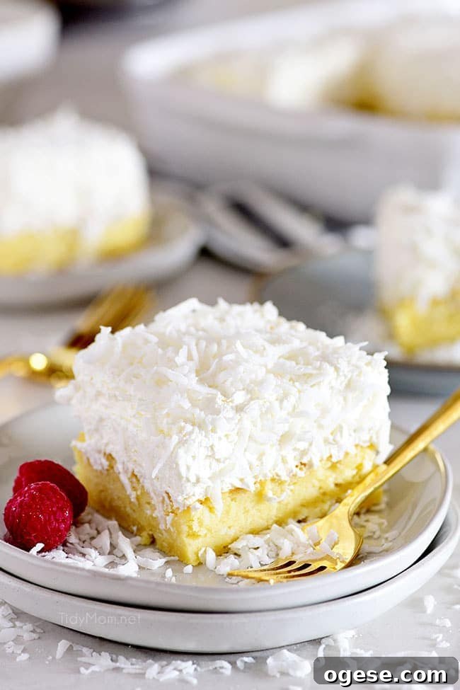 Moist Coconut Cake Recipe with Video Tutorial 9 coconut cake on a plate with a gold fork
