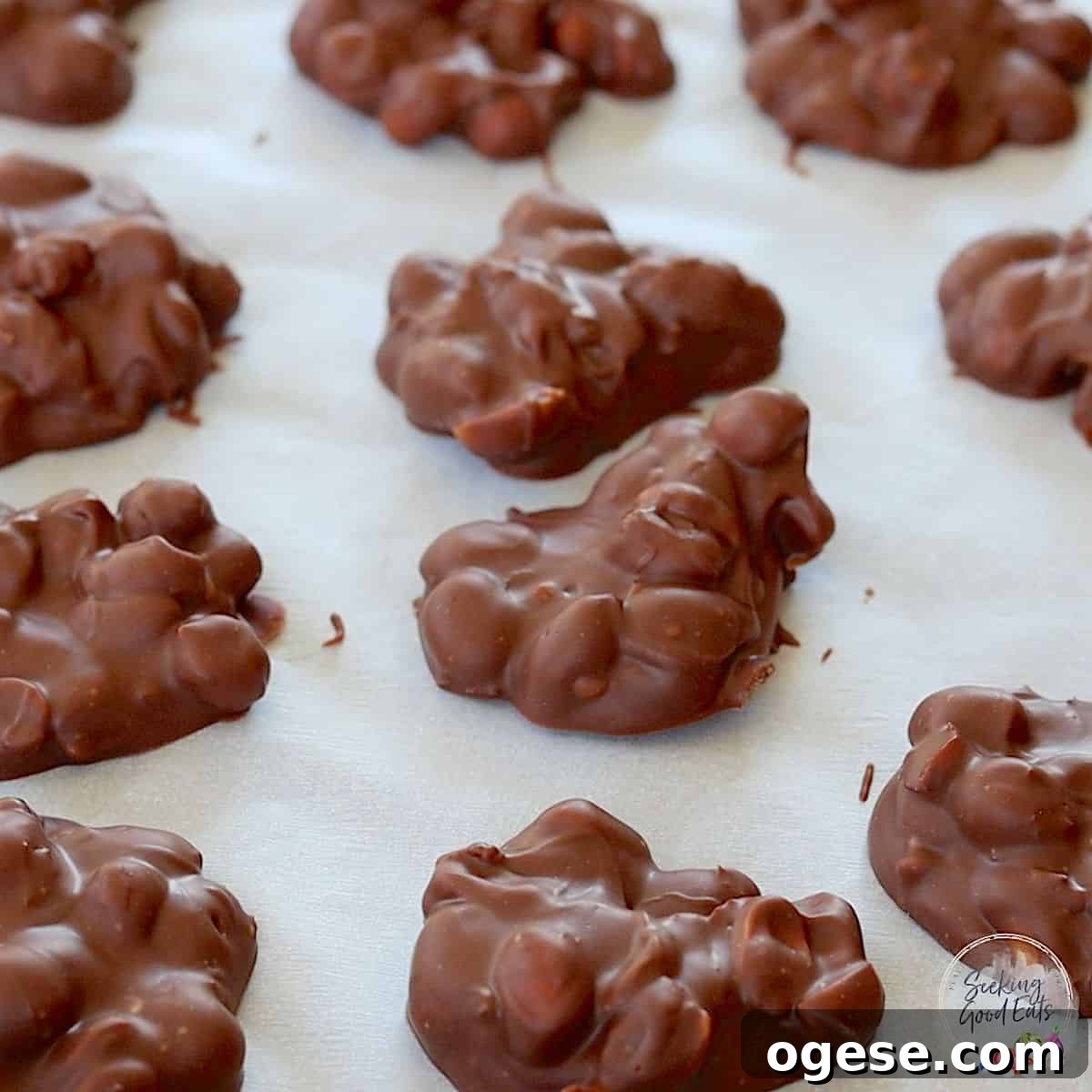 4-Ingredient Crockpot Peanut Clusters Recipe 7 Refrigerated and firm crock pot chocolate peanut clusters on a baking sheet.