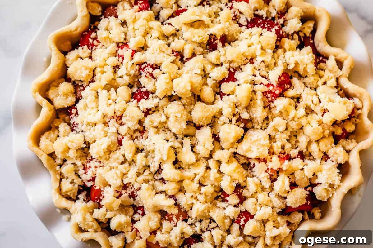 strawberry rhubarb pie with crumble on top ready to bake.