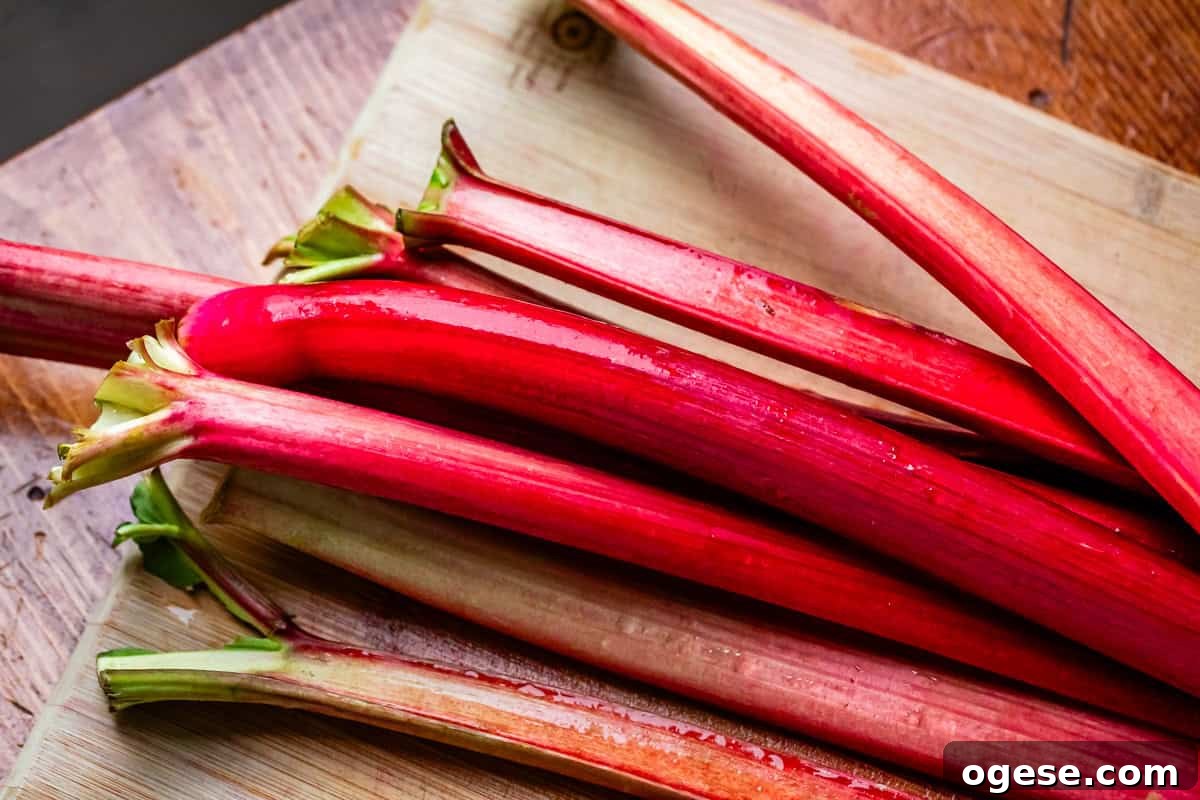 a bunch of rhubarb stalks on a wooden cutting board.