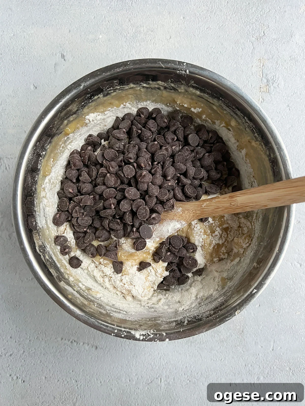 Adding chocolate chips to banana bread batter.