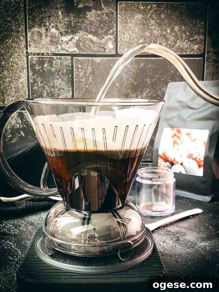 Innovative Coffee Dripper for Richer Pour-Over Flavor 5 Gooseneck kettle pouring hot water into the Clever Dripper filled with ground coffee.