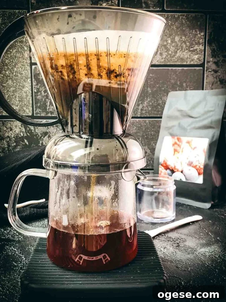 Innovative Coffee Dripper for Richer Pour-Over Flavor 6 Clever Dripper placed on top of a glass carafe as freshly brewed coffee flows down into it.