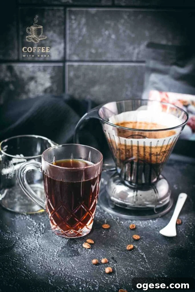 Innovative Coffee Dripper for Richer Pour-Over Flavor 8 Used Clever Dripper with wet coffee grounds beside a glass mug of freshly brewed coffee.