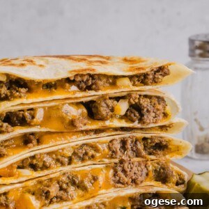 One-Pan Lemon Salmon and Orzo Recipe 15 Cheeseburger quesadillas sliced and stacked on a wood cutting board.