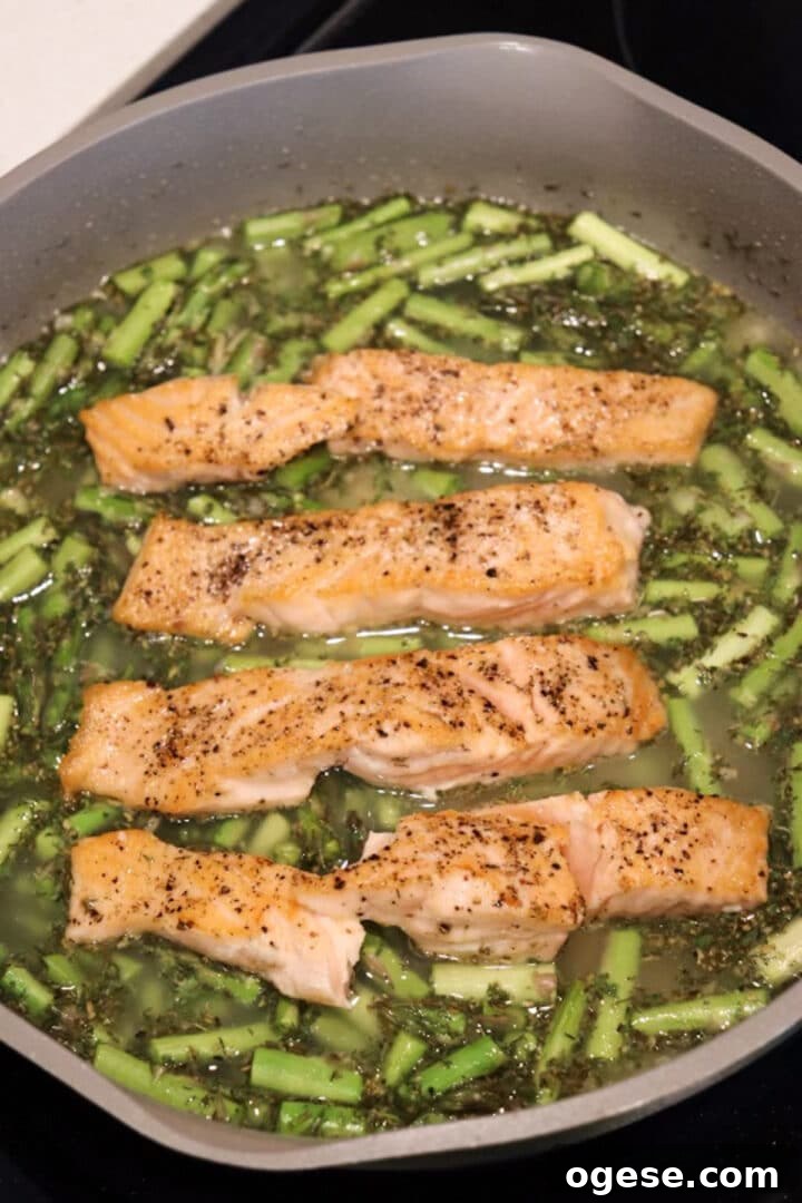 One-Pan Lemon Salmon and Orzo Recipe 10 Salmon and orzo recipe prepared in a skillet, before the orzo has completed cooking