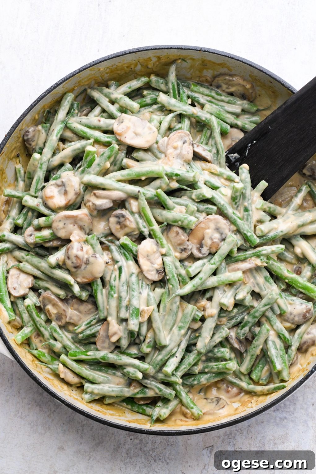 Dairy-Free Cashew Cream Green Bean Casserole (Gluten-Free) 12 Green beans tossed with creamy mushroom sauce in a large ceramic skillet.