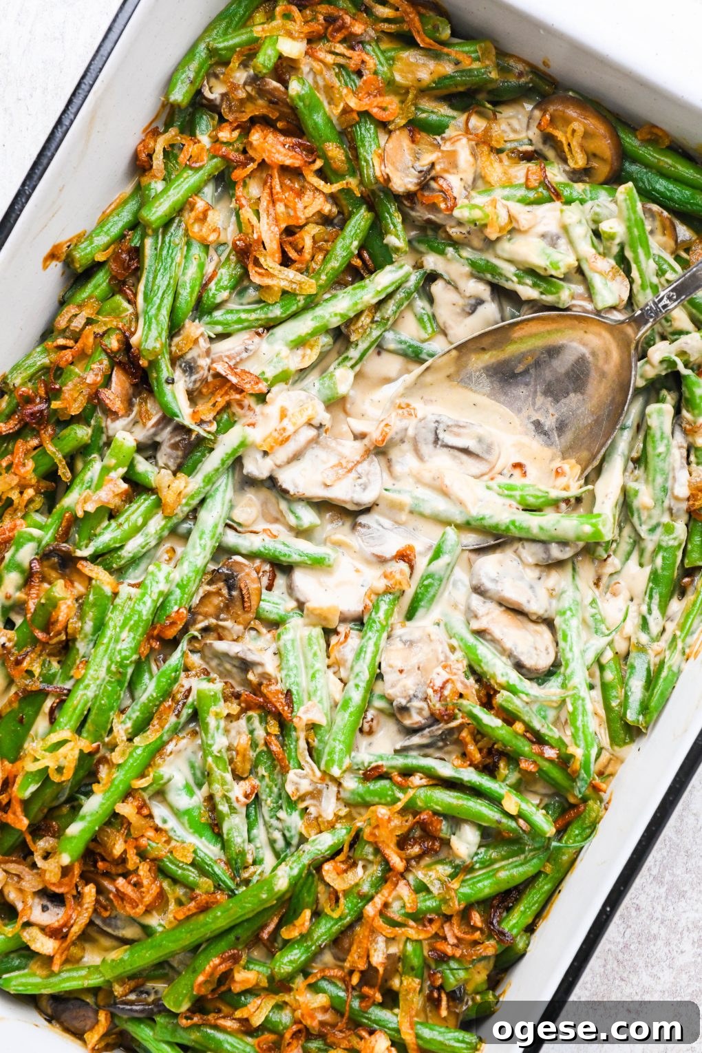 Dairy-Free Cashew Cream Green Bean Casserole (Gluten-Free) 17 Baked gluten free green bean casserole topped with crispy shallots, with a scoop taken out to expose the creamy interior.