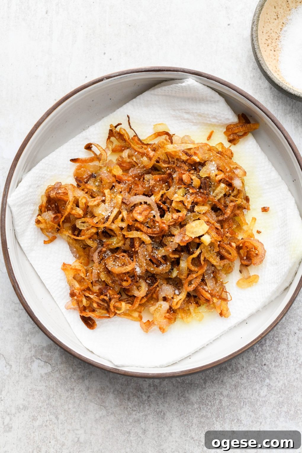 Dairy-Free Cashew Cream Green Bean Casserole (Gluten-Free) 6 Crispy fried shallots on a paper towel in a small dish topped with salt.
