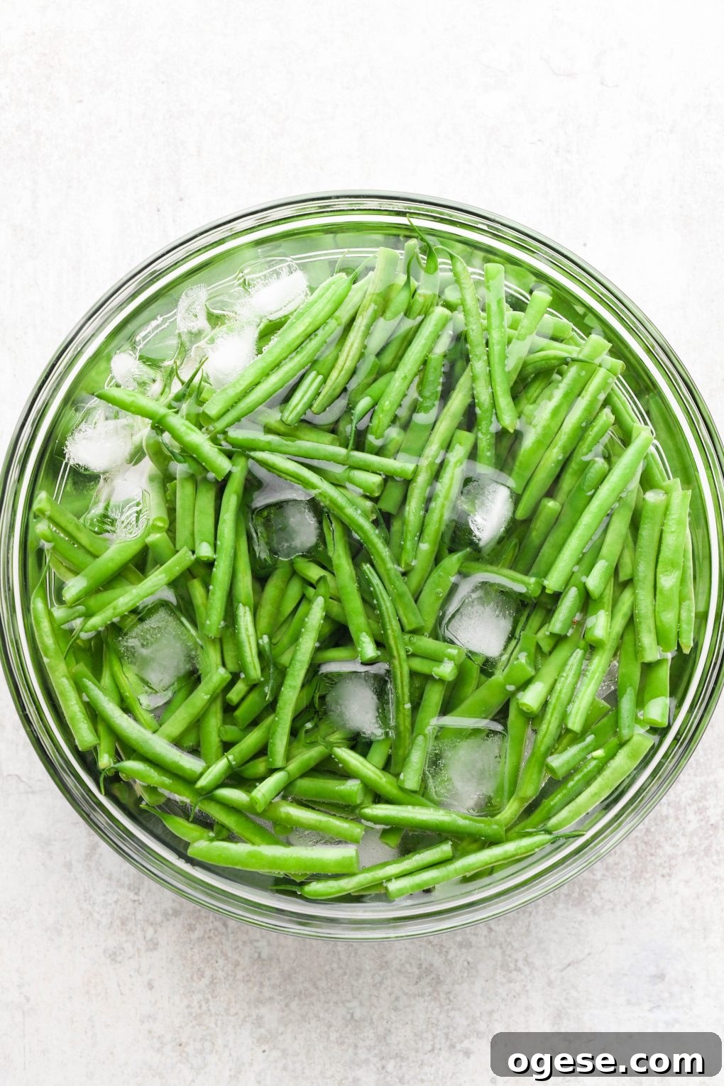 Dairy-Free Cashew Cream Green Bean Casserole (Gluten-Free) 7 Blanched green beans in a bowl of ice water.