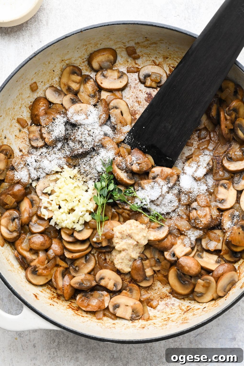 Dairy-Free Cashew Cream Green Bean Casserole (Gluten-Free) 8 Sauteed mushrooms and onions in a large ceramic skillet with fresh thyme, garlic, salt, and pepper.