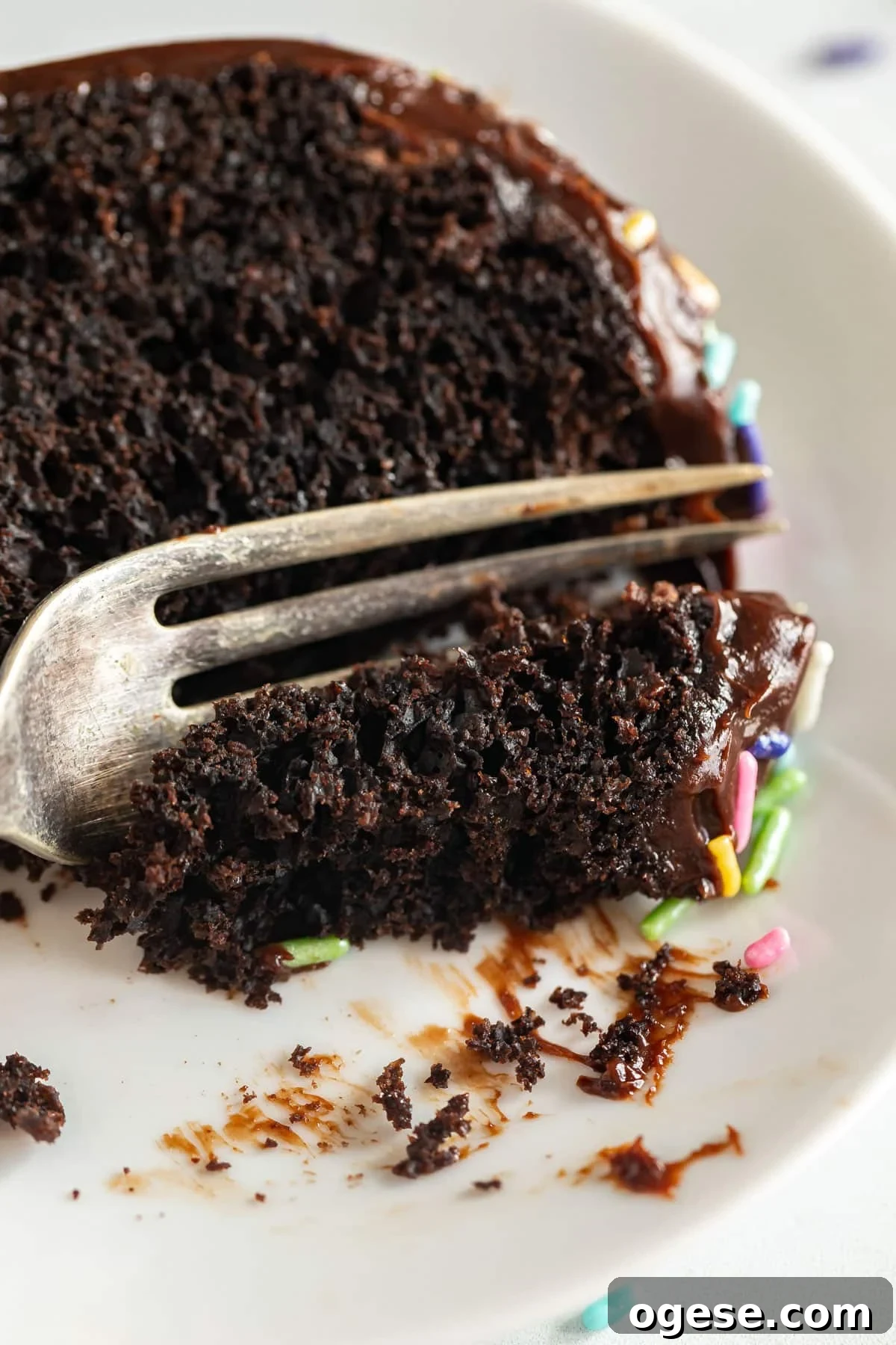 Ultimate Chocolate Overload Cake Recipe for True Chocoholics 13 A close up of a fork cutting a bite of a slice of chocolate cake.