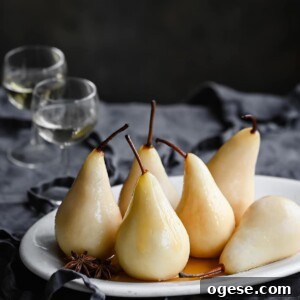 White wine poached pears on table with two glasses of wine.