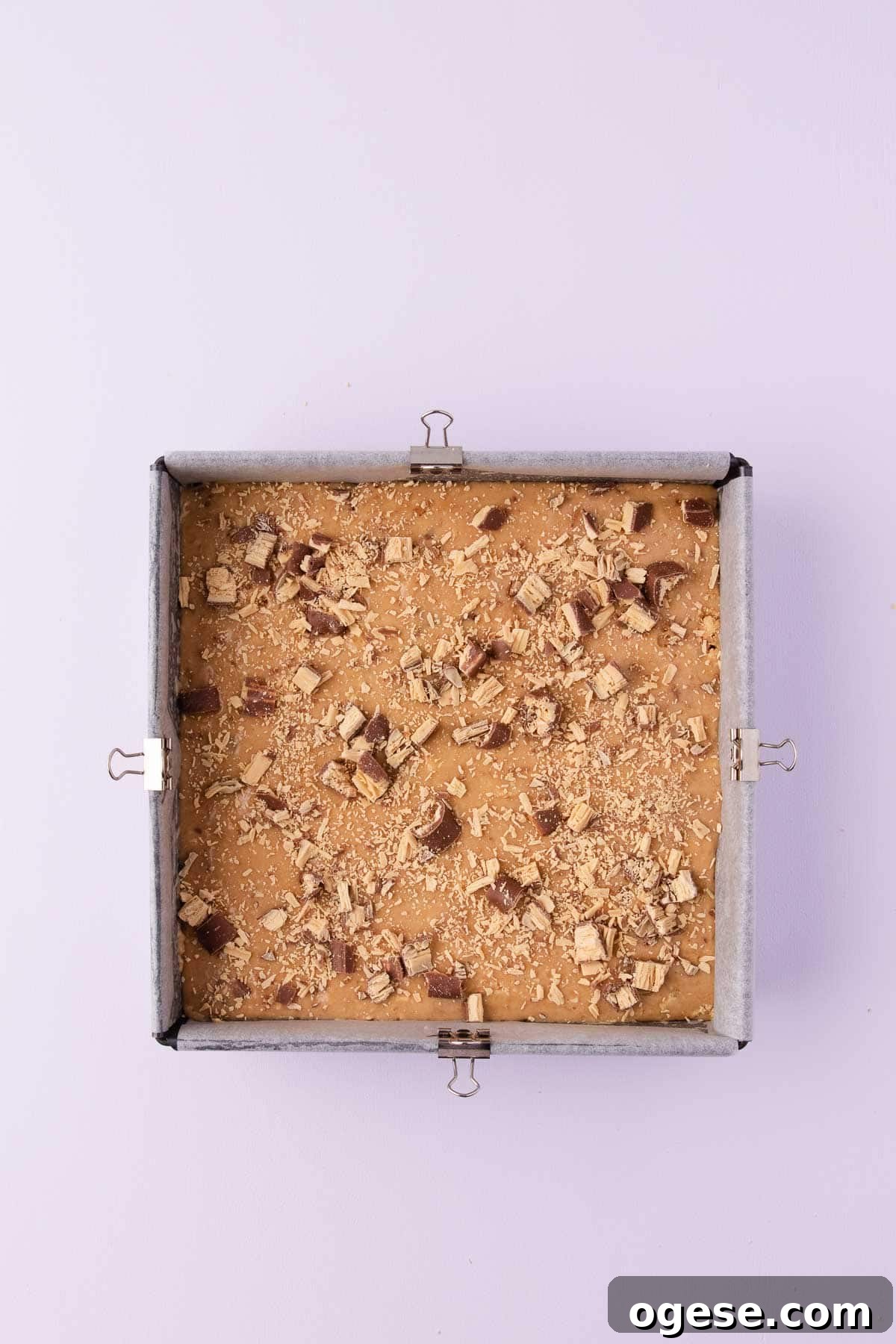 The Caramilk slice mixture pressed into a square cake pan, and sprinkled on top with extra caramilk twirls.